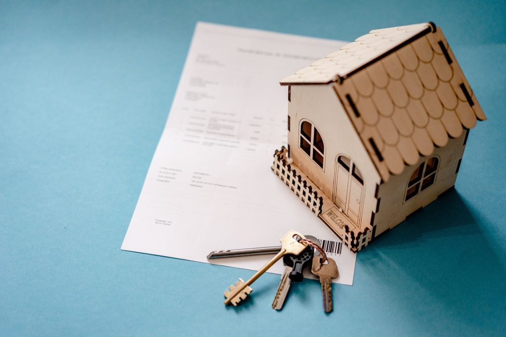 Maqueta de una casa y unas llaves sobre un documento